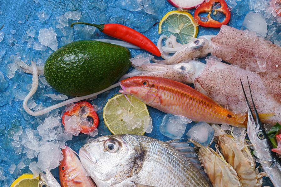 Whole fish, squid and shrimp on crushed ice with lemon, chili and avocado